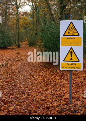 Le signe de danger sur le chemin piétonnier à travers la zone de formation du ministère de la Défense Grayshot Hampshire England UK Banque D'Images