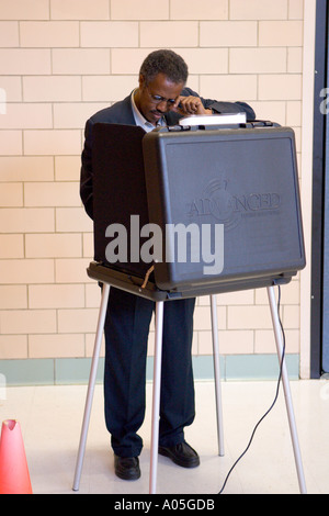 African American électeur au scrutin de l'élection présidentielle en utilisant des machines à écran tactile à Arlington en Virginie Banque D'Images