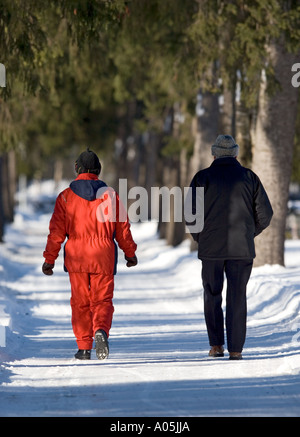 Vieux couple marchant dans une ruelle de l'épinette à l'hiver , Finlande Banque D'Images