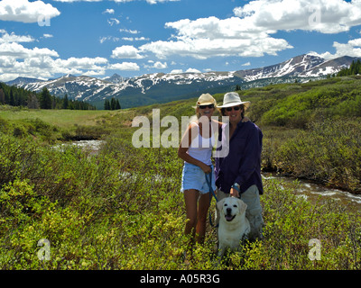 Couple walking dog dans le pré près de Vail Colorado États-unis sommet Rocky Mountains Banque D'Images