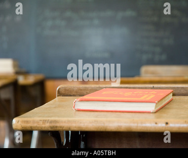 Une salle de classe historique de vieille école avec un tableau noir flou et un livre sur un bureau Banque D'Images