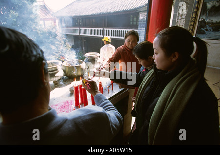 Chine Yunnan Dali Temple Zhonghe adorateurs d'encens sur les bougies d'éclairage Banque D'Images