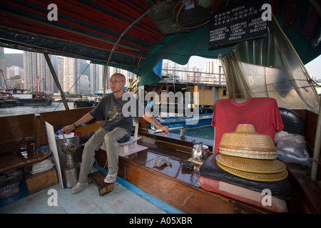 L'homme chinois une jonque chinoise en direction du port d'Aberdeen à Hong Kong Banque D'Images