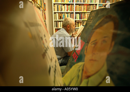 Un homme âgé lit un livre dans une librairie d'occasion à Jérusalem-Ouest israël Banque D'Images