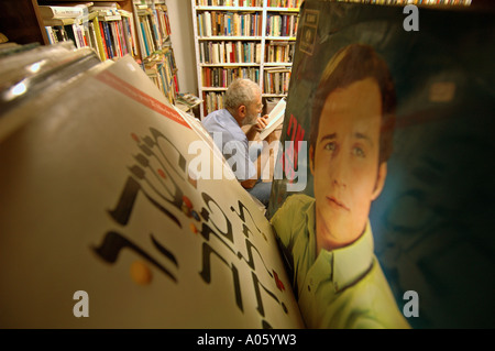 Un homme âgé lit un livre dans une librairie d'occasion à Jérusalem-Ouest israël Banque D'Images