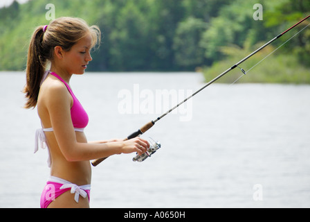 18 yr old girl standing on dock à la pêche en lac Banque D'Images