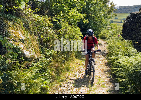 Femme du vélo de montagne sur une piste entre Clapham et dans le Yorkshire Dales Austwick Banque D'Images