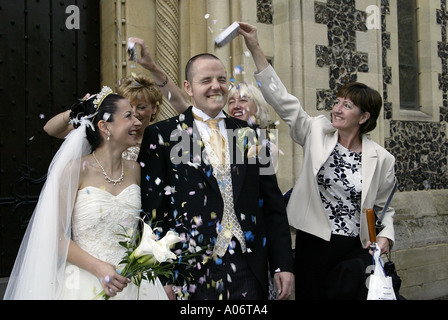 Mariés à uk avec des invités de mariage confettis jeter Banque D'Images