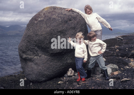 L'Écosse du côté du loch vent poser 3 enfants dans les cavaliers de Aran vacances tourisme écossais dans les années 70, poussant pour la famille rocher au bord de l'album photo UK Banque D'Images