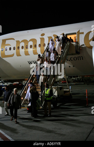 Unis avion avec passagers débarqués dans la nuit à l'aéroport international de Dubaï Emirats arabes unis Moyen-Orient Banque D'Images