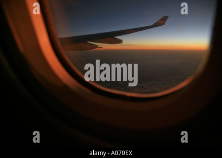 Crépuscule et le coucher de soleil pris de la fenêtre de l'avion indiquant des couleurs chaudes dans le ciel du soir Banque D'Images