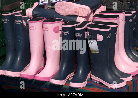 Bottes Wellington empilés sur le stand de vente à l'événement de plein air en milieu rural Banque D'Images