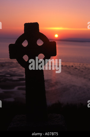 L'église St Ismaël Carmarthenshire pierre tombale en forme de croix celtique au coucher du soleil au Pays de Galles UK Banque D'Images