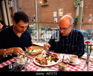 Les hommes d'affaires de Manchester alimentaire prendre un déjeuner de travail dans un café grec Dimitris Banque D'Images