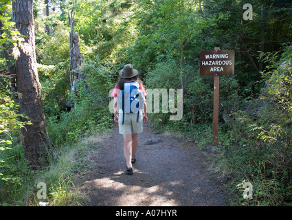 Randonneur femme passé marche avertissement signe harzardous salon col Deception state park l'état de Washington, USA Banque D'Images