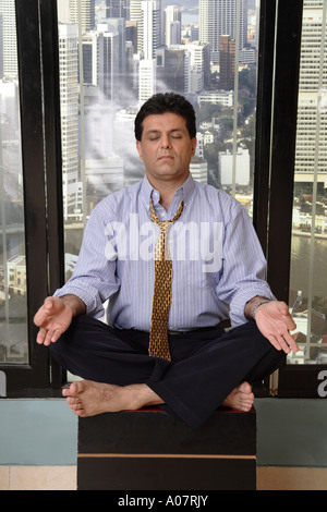 Exercices de yoga l'homme pour soulager le stress dans sa cabine à l'arrière-plan de la ville Banque D'Images