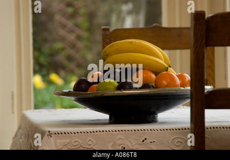 Bol de fruits sur une table de petit-déjeuner donnant sur le jardin Banque D'Images