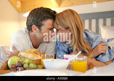 Paar beim gemeinsamen Fruehstueck im Bett, couple having breakfast together in bed Banque D'Images