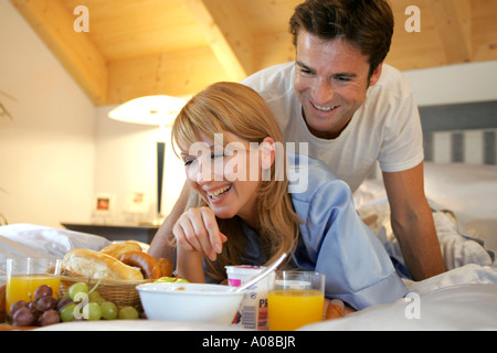 Paar beim gemeinsamen Fruehstueck im Bett, couple having breakfast together in bed Banque D'Images