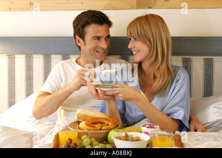 Paar beim gemeinsamen Fruehstueck im Bett, couple having breakfast together in bed Banque D'Images