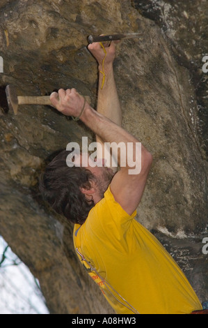 Climber Tobias Wolf part un forage forage manuel avec la vis de protection Banque D'Images