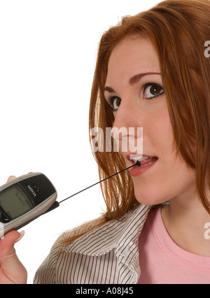 Jeune femme caucasienne attendant un appel téléphonique important sur un smartphone, exprimant anticipation.USA Banque D'Images