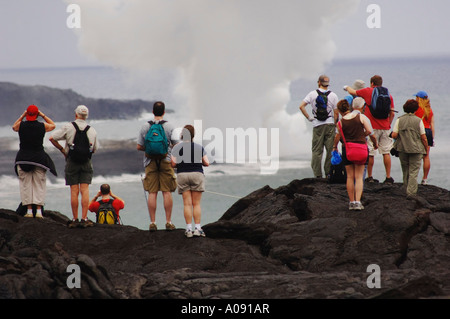 Les touristes debout sur la lave, regardant l'océan, Hawaii, USA Banque D'Images