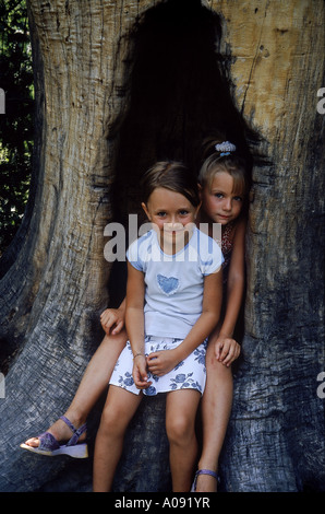 Deux filles assis dans une attente dans un arbre Banque D'Images