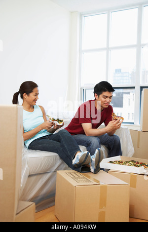 Couple Eating Pizza à nouveau condo Banque D'Images