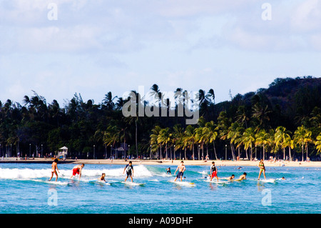 Tas de surfers équitation une longue vague de Waikiki Beach à Oahu Hawaii Banque D'Images