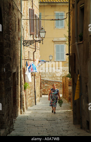 Ruelle étroite marche dame transportant des fleurs Colle di Val d'Elsa Val di Chianti Toscane Italie Europe de l'UE Banque D'Images