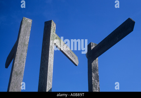 Trois panneaux en bois fingerpost fermer ensemble sous ciel bleu clair indiquant sentier public et orientée dans 3 directions différentes Banque D'Images