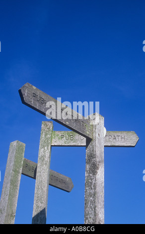 Trois panneaux en bois fingerpost fermer ensemble sous ciel bleu clair indiquant sentier public et orientée dans 3 directions différentes Banque D'Images