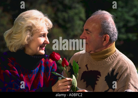 D'âge mûr homme donnant à roses Banque D'Images