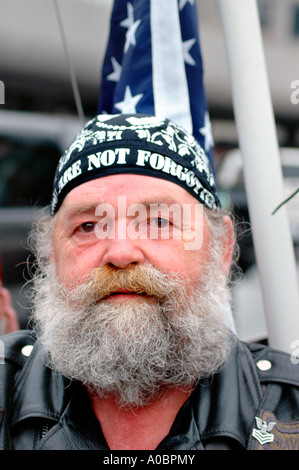 Homme senior Vietnam vétérinaire de guerre avec barbe et drapeau pour se souvenir des prisonniers de guerre qui sont encore disparus Banque D'Images