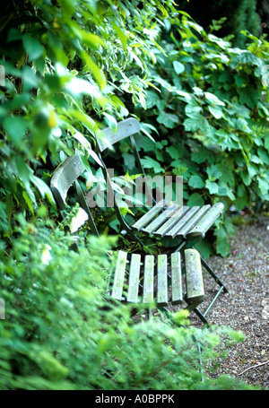 Chaises de style café français avec sièges à lattes dans un jardin Banque D'Images
