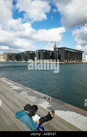 La lecture de l'homme sur la jetée et Nordea Bank siège à Christianhavn, Copenhague, Danemark Banque D'Images