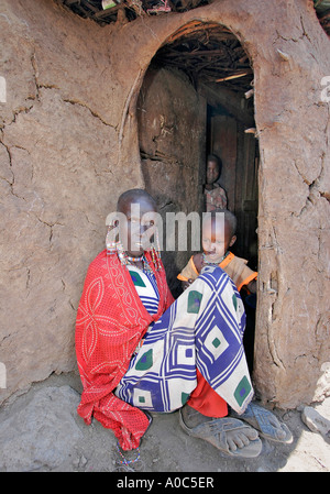 Personnes âgées masaï et de l'enfant par dung hut Banque D'Images