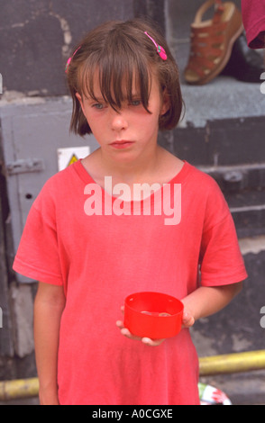 Les sans-abri de l'âge de l'enfant 10 water holding out cup pour les dons. Torun Pologne Banque D'Images