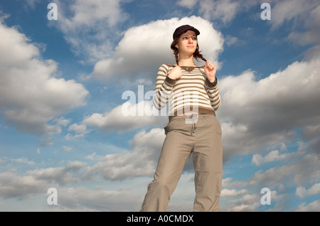 Jeune femme aux tresses wearing cap standing outdoors Banque D'Images