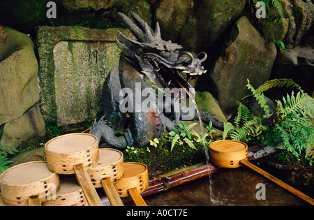 Une fontaine d'eau en forme de dragon à l'entrée d'un sanctuaire Shinto du Japon Kyoto Banque D'Images