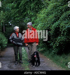 SENIOR COUPLE OUT WALKING DOG EN PAYS Banque D'Images