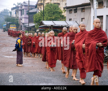Photographie d'une longue lignée de moines sur leurs matin rondes de la mendicité pour l'aumône à Bago au Myanmar 2006 Banque D'Images