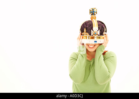 Jeune femme tenant la couronne sur la tête du parti Banque D'Images