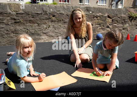 Les jeunes enfants de l'école d'art en plein air ayant une leçon avec jeune femme enseignant Banque D'Images