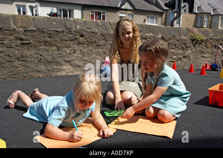 Les jeunes enfants de l'école d'art en plein air ayant une leçon avec jeune femme enseignant Banque D'Images