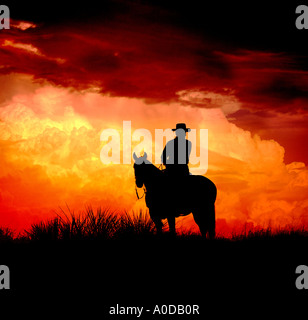 Cowboy à cheval au coucher du soleil avec orage en arrière-plan. Banque D'Images