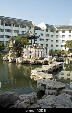 Stepping Stones menant à une petite pagode sur une île dans un lac, Bamboo Grove Hotel, Suzhou Banque D'Images