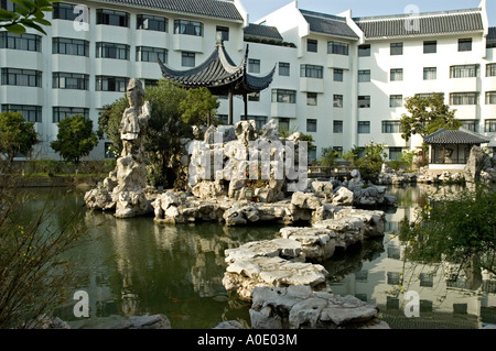 Stepping Stones menant à une petite pagode sur une île dans un lac, Bamboo Grove Hotel, Suzhou Banque D'Images