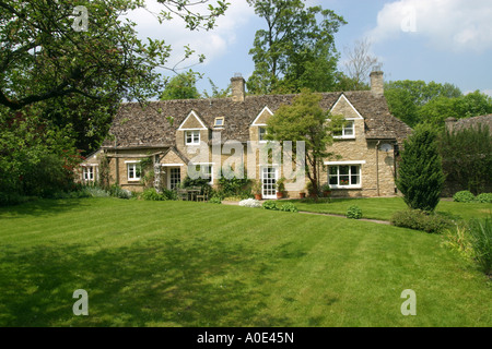 Jolie maison en pierre, dans un grand jardin avec pelouse. Banque D'Images